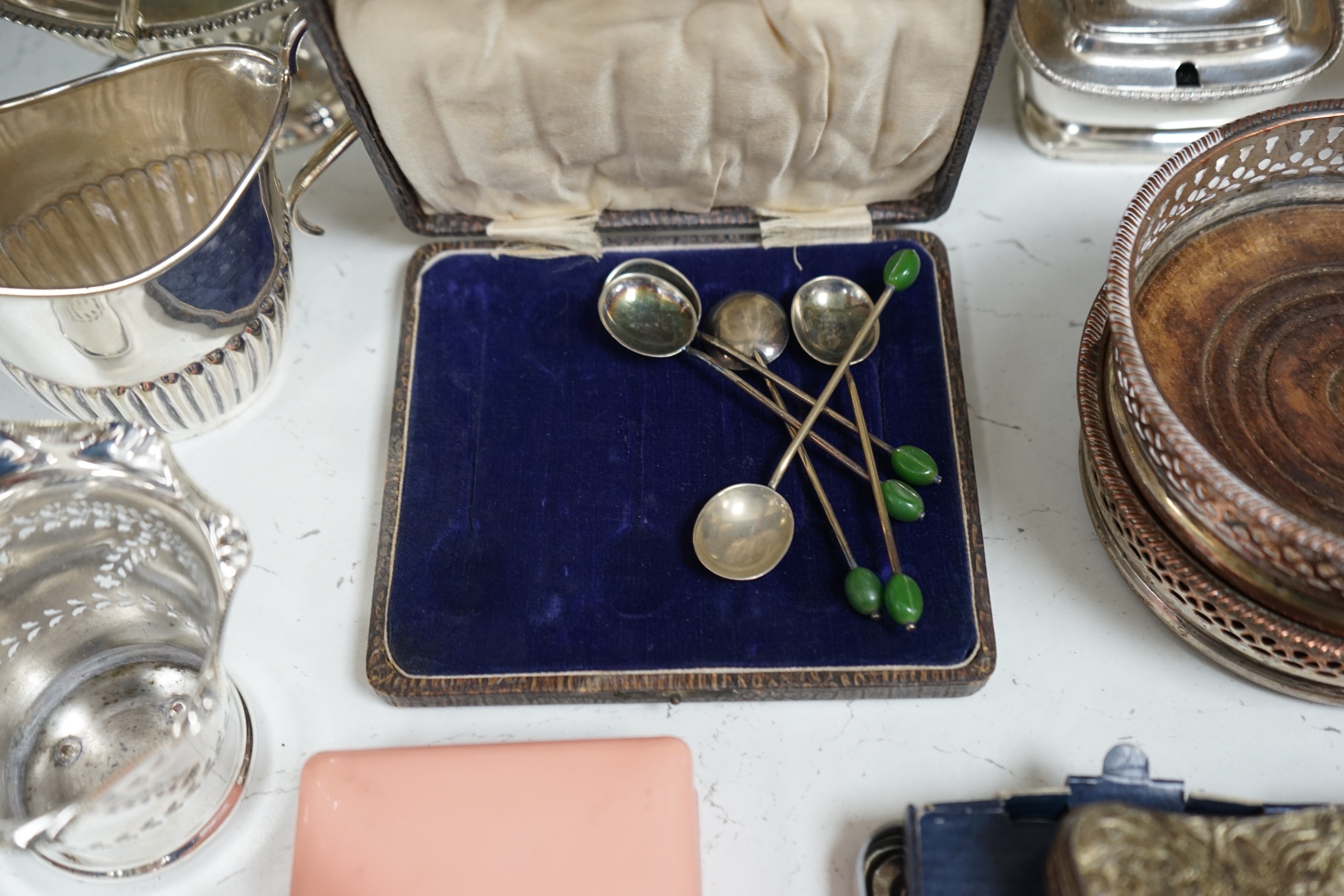 A collection of mixed silver plated wares, to include a pair of wine coasters, cream jug, novelty spoons, etc.